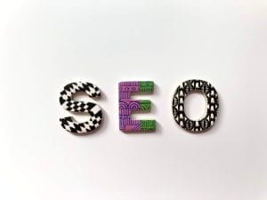 The letters "SEO" are arranged side by side, each with distinct black-and-white or purple patterns, on a plain white background.